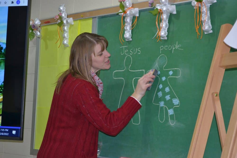 Teacher showing Jesus and people on the chalkboard