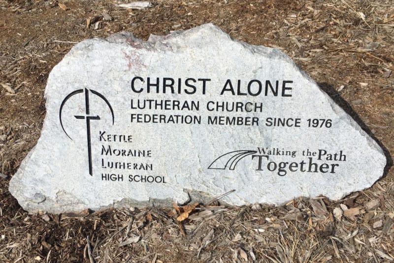 christ alone lutheran church federation member since 1976 for kettle moraine lutheran high school written on a stone in front of the building